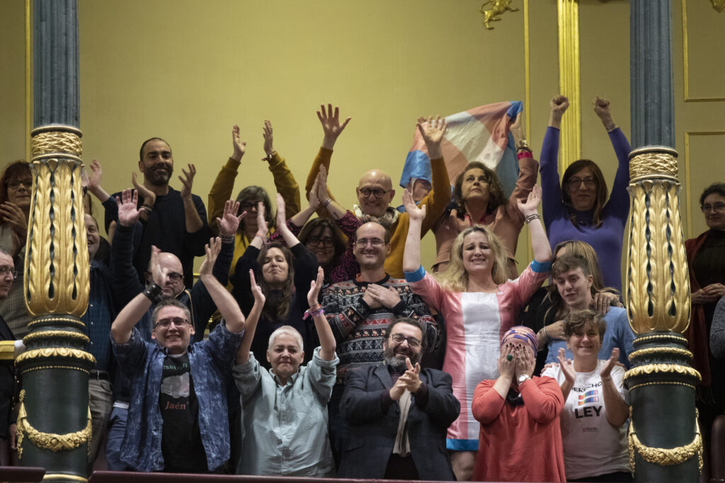 Activistas LGTBI+ presentes en la votación en el Congreso de los Diputados celebran la aprobación de la ley. Fuente: felgtb.org